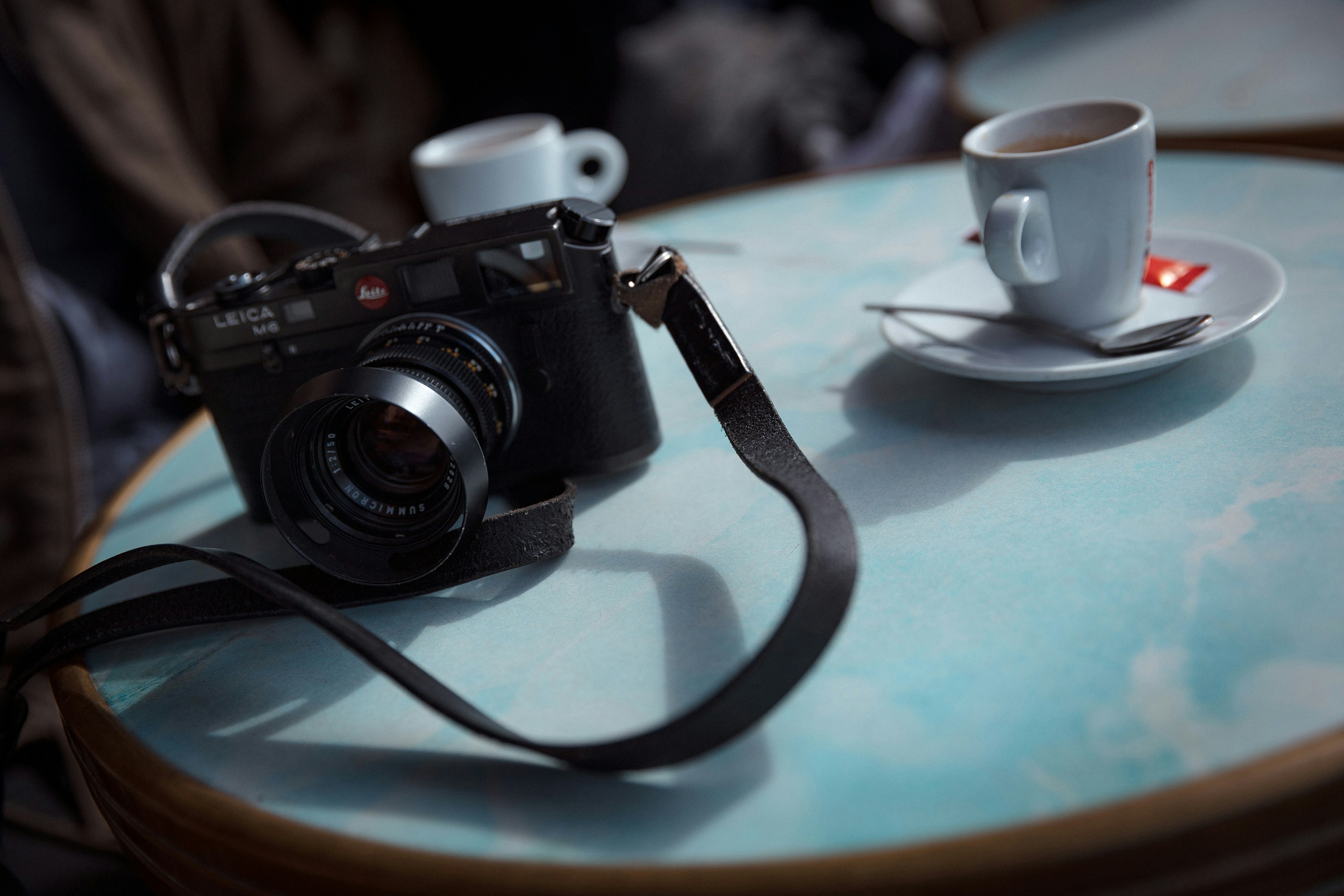 a camera and cups left on a cafe table