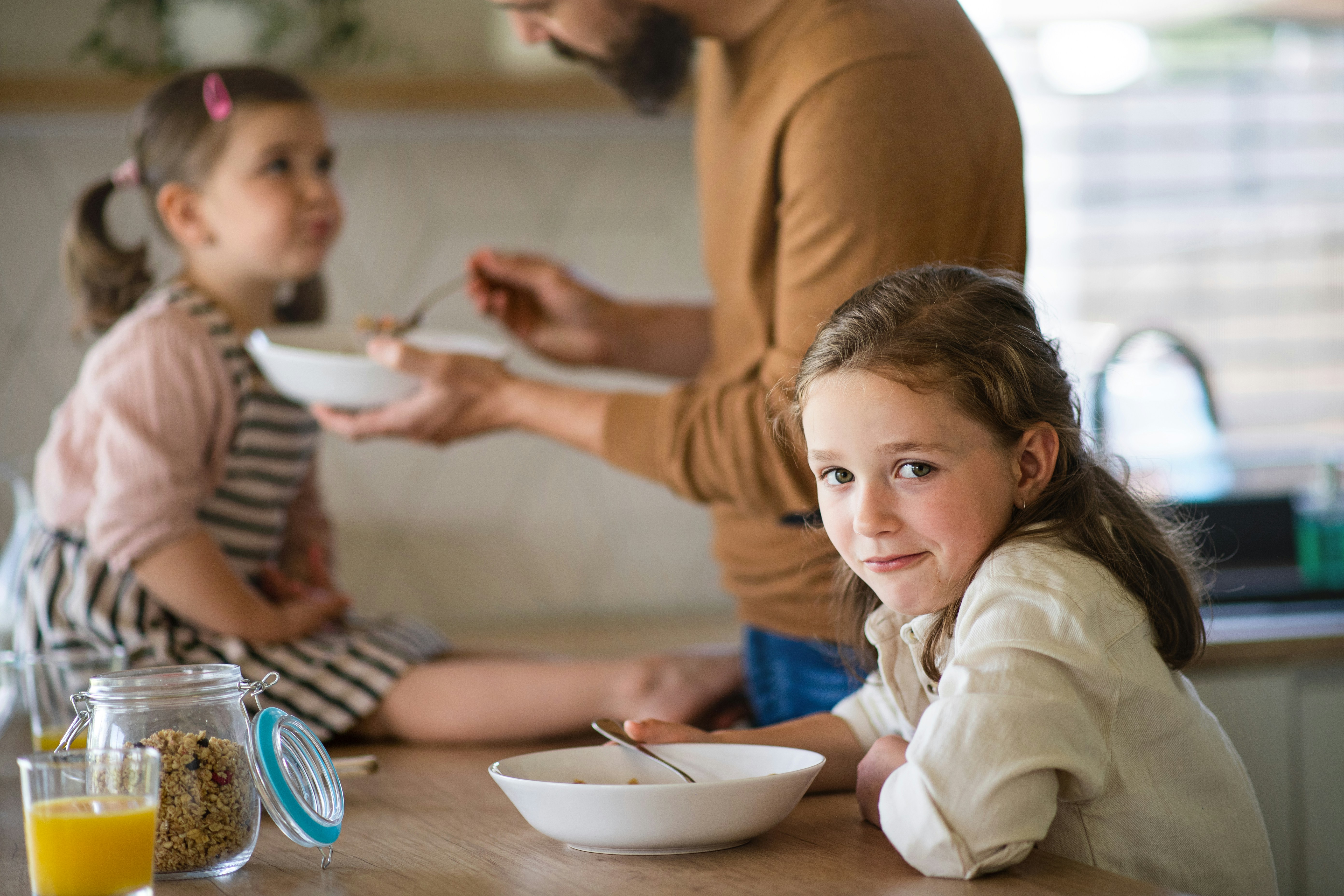a father serving breakfast to his children