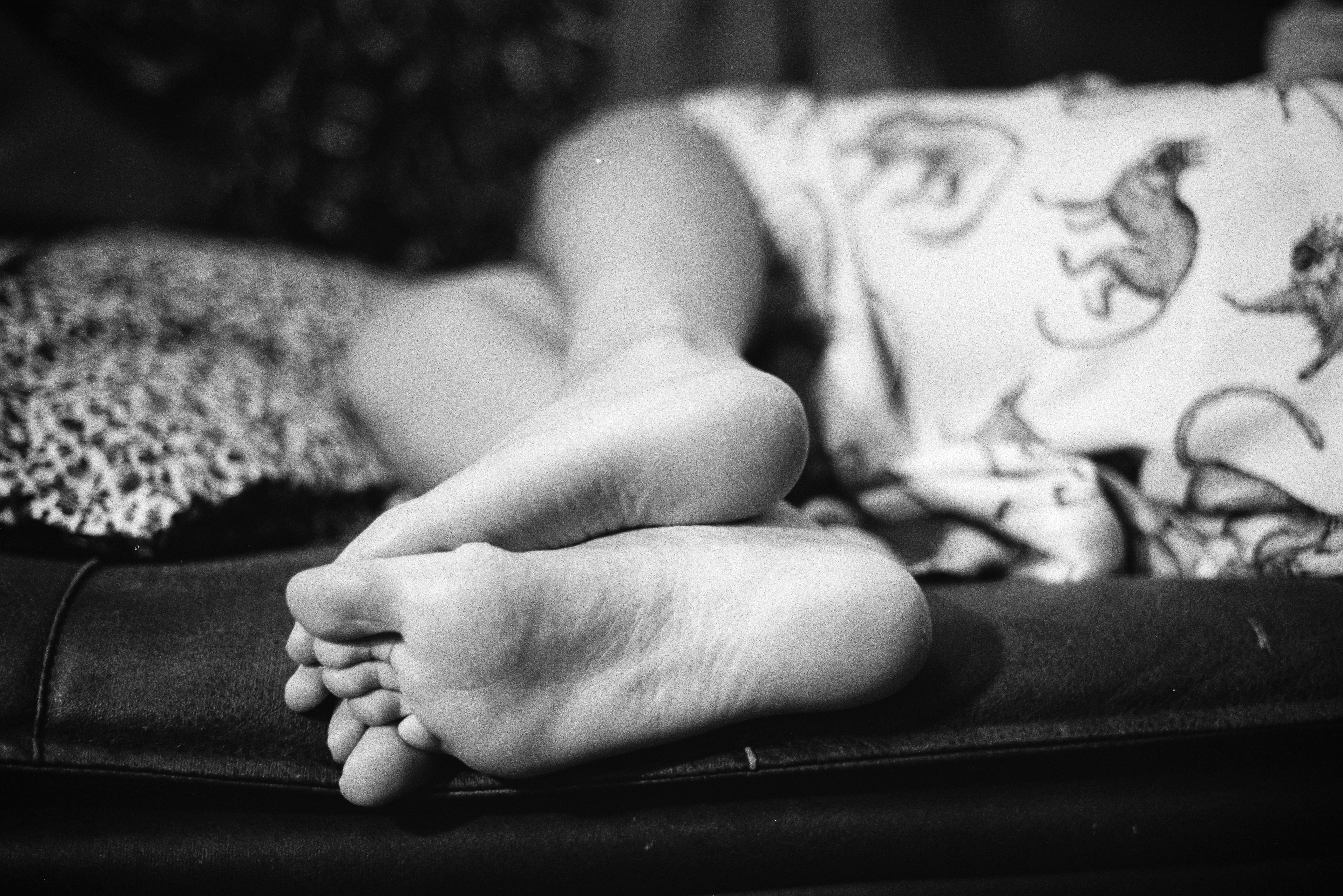 a child asleep with their feet on a cushion