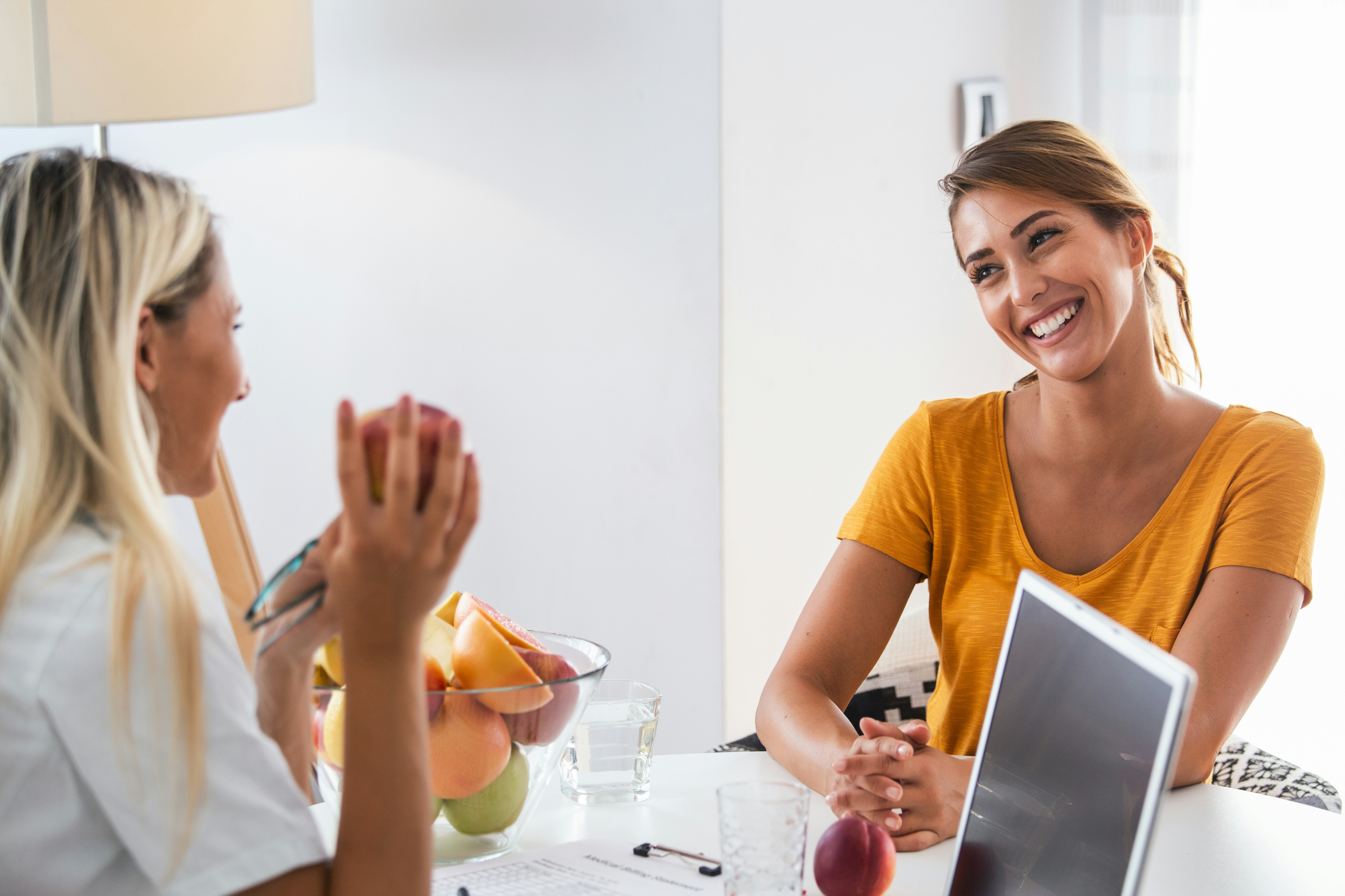 two women talking over a tablet in a kitchen