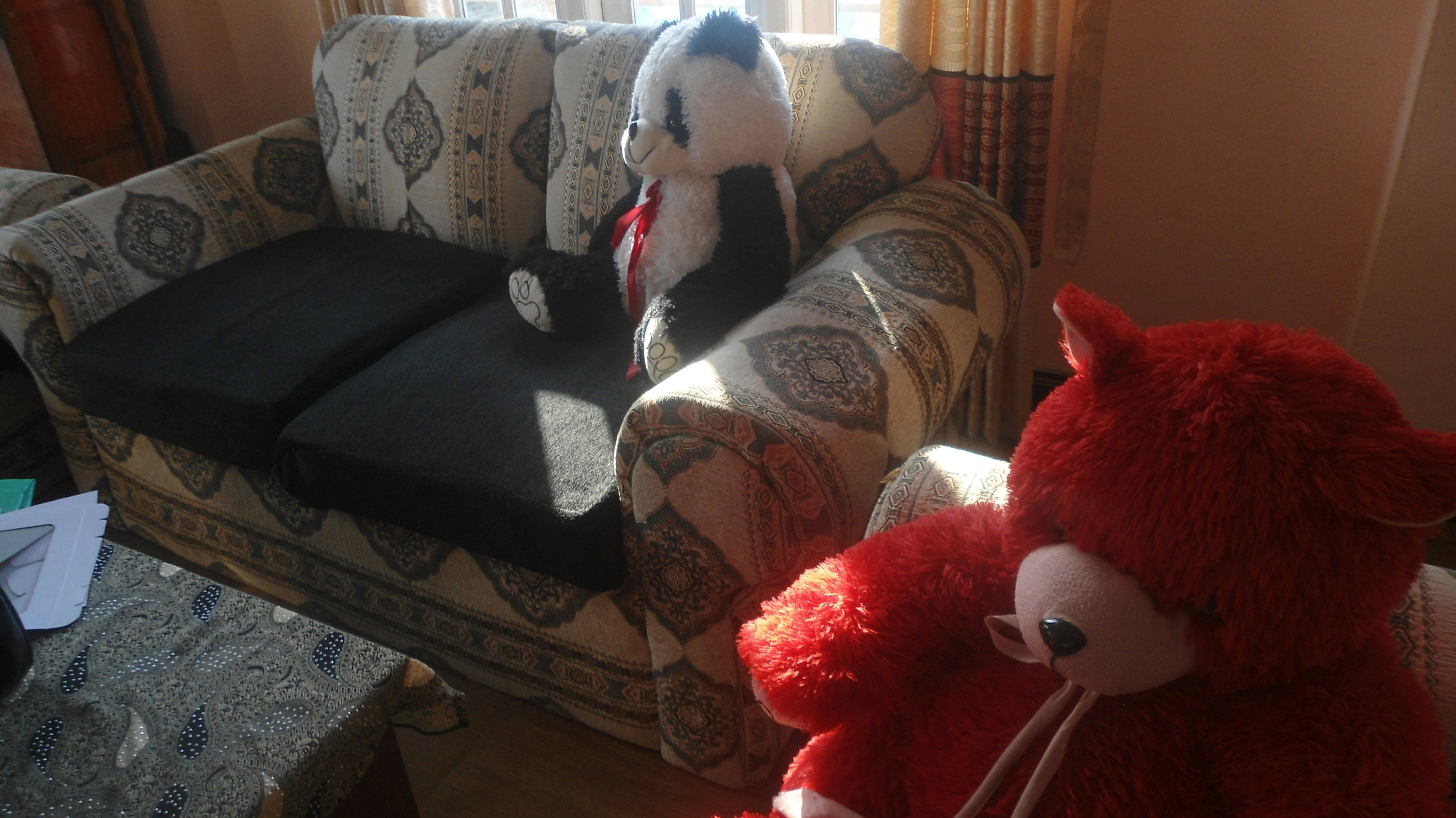 a red soft toy left on a sofa in a family living room