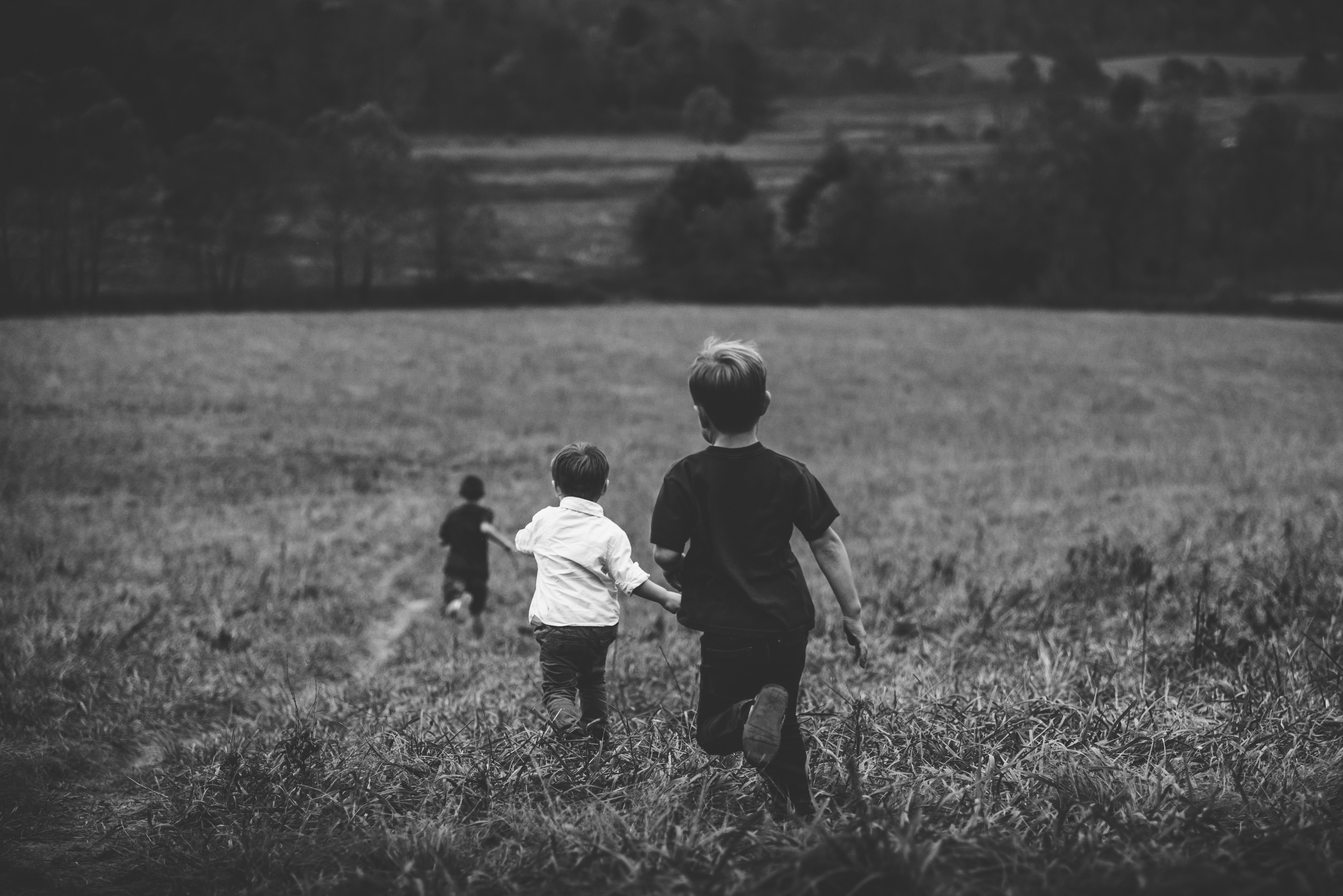 three children running away across a field