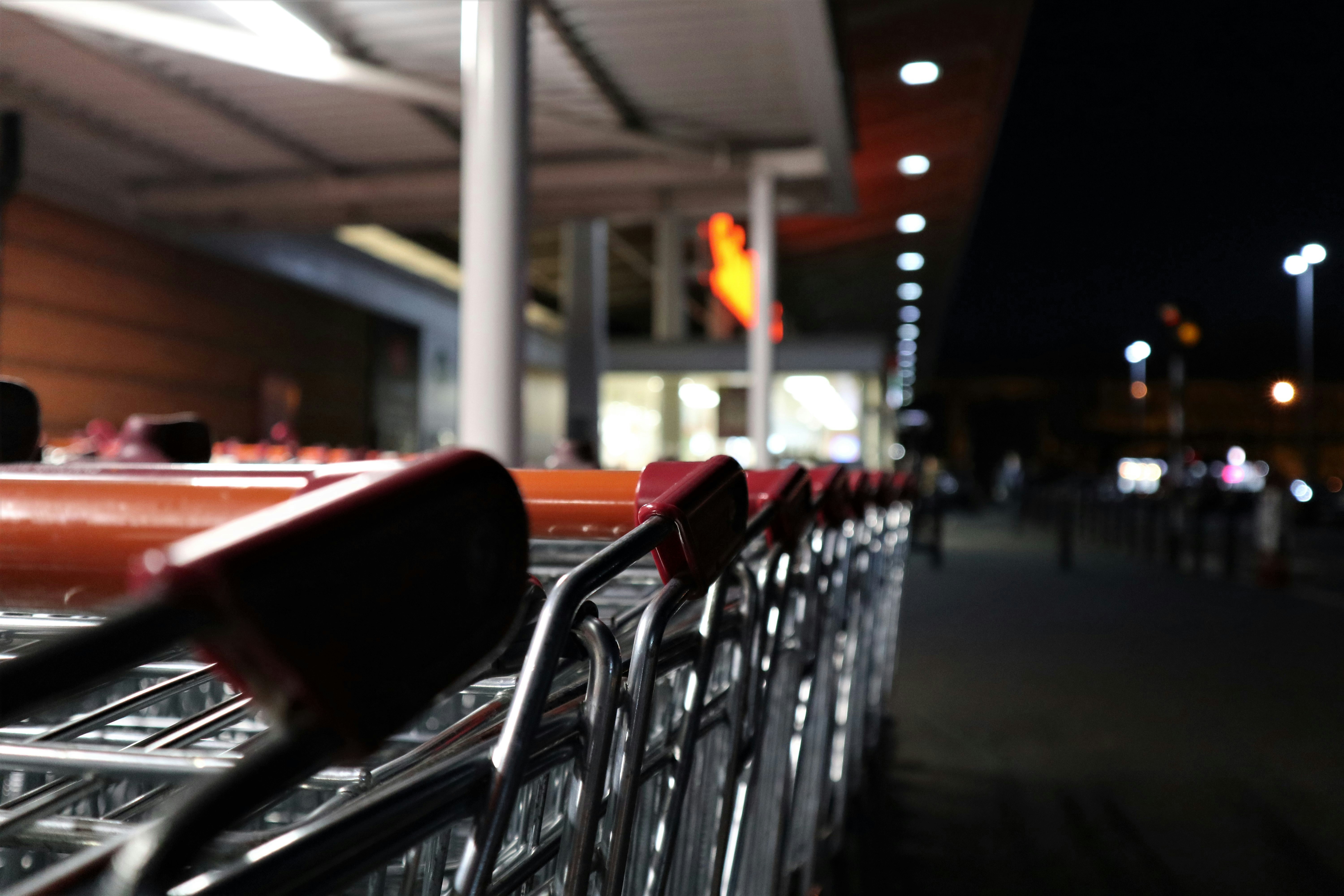 a row of shopping trolleys outside a store at night