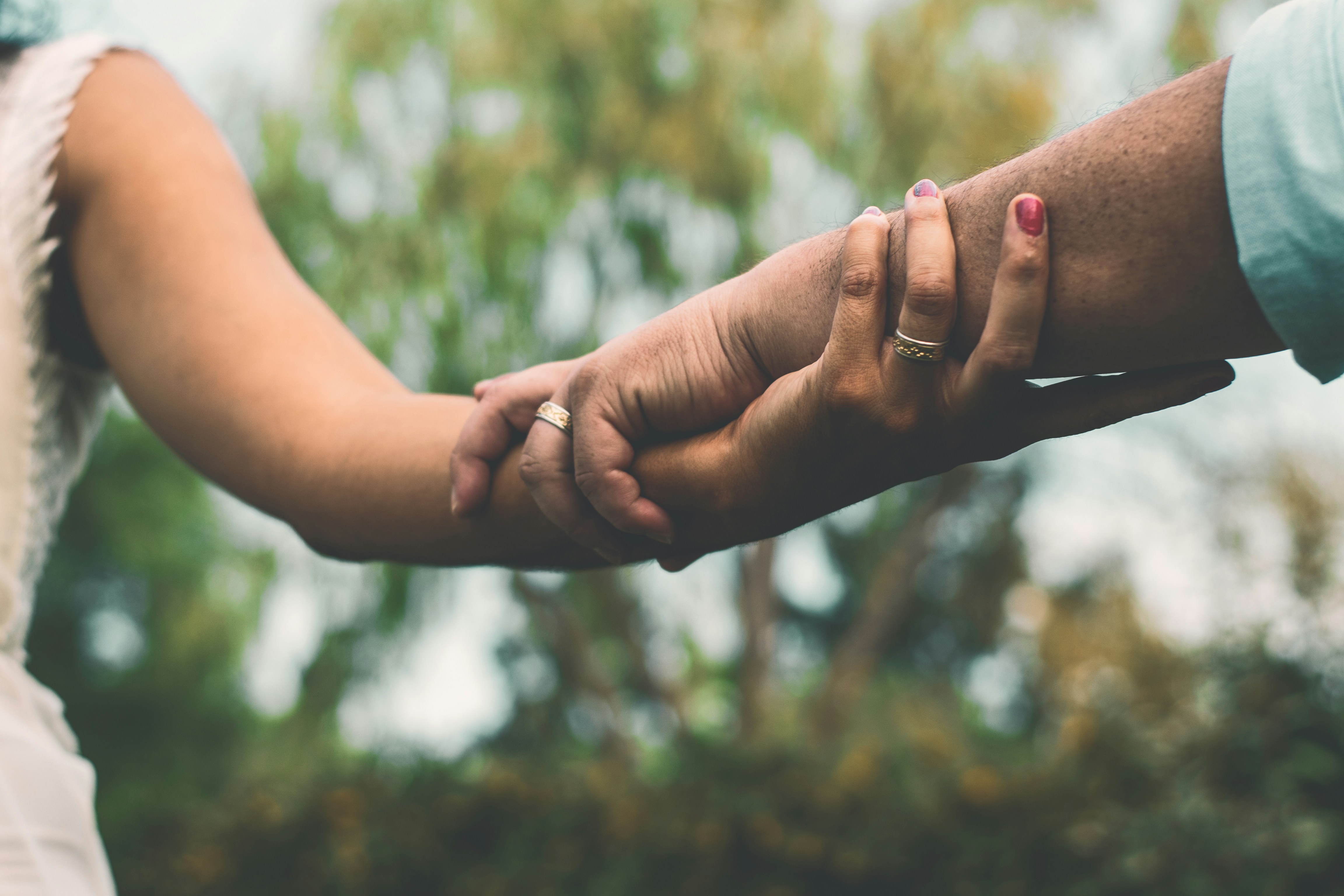 two hands held loosely outdoors