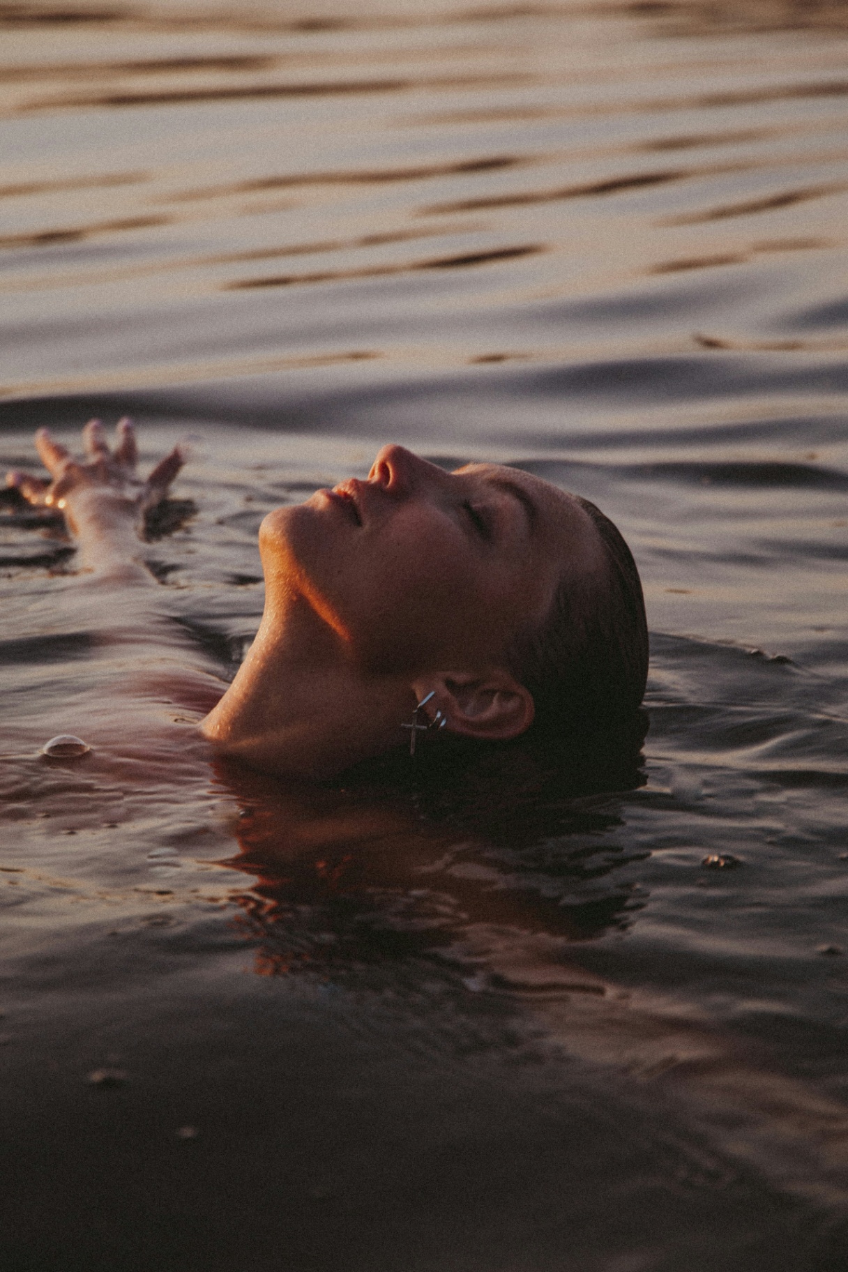 a person floating peacefully in calm water at sunset