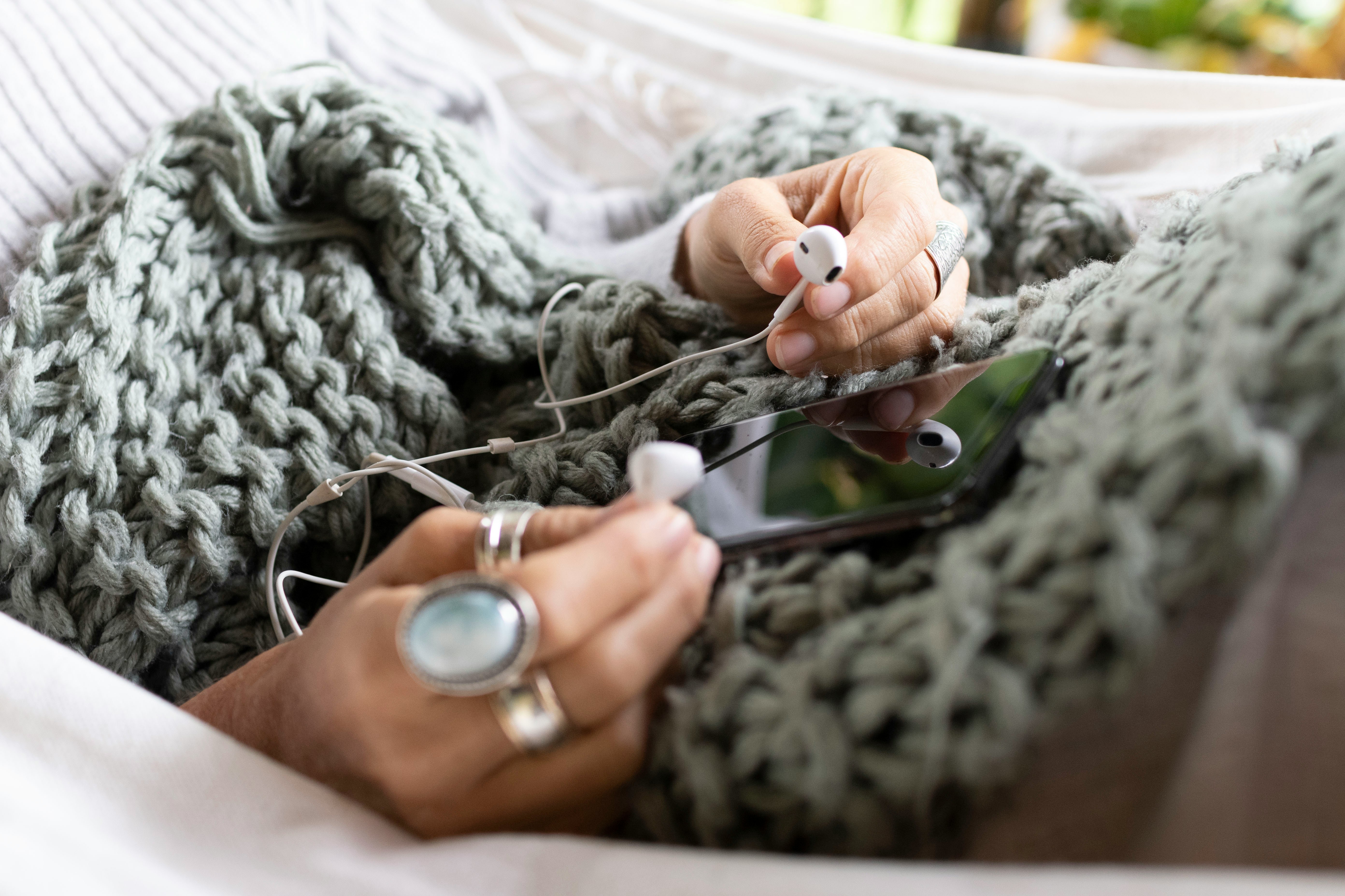 hands resting on a chunky knitted blanket