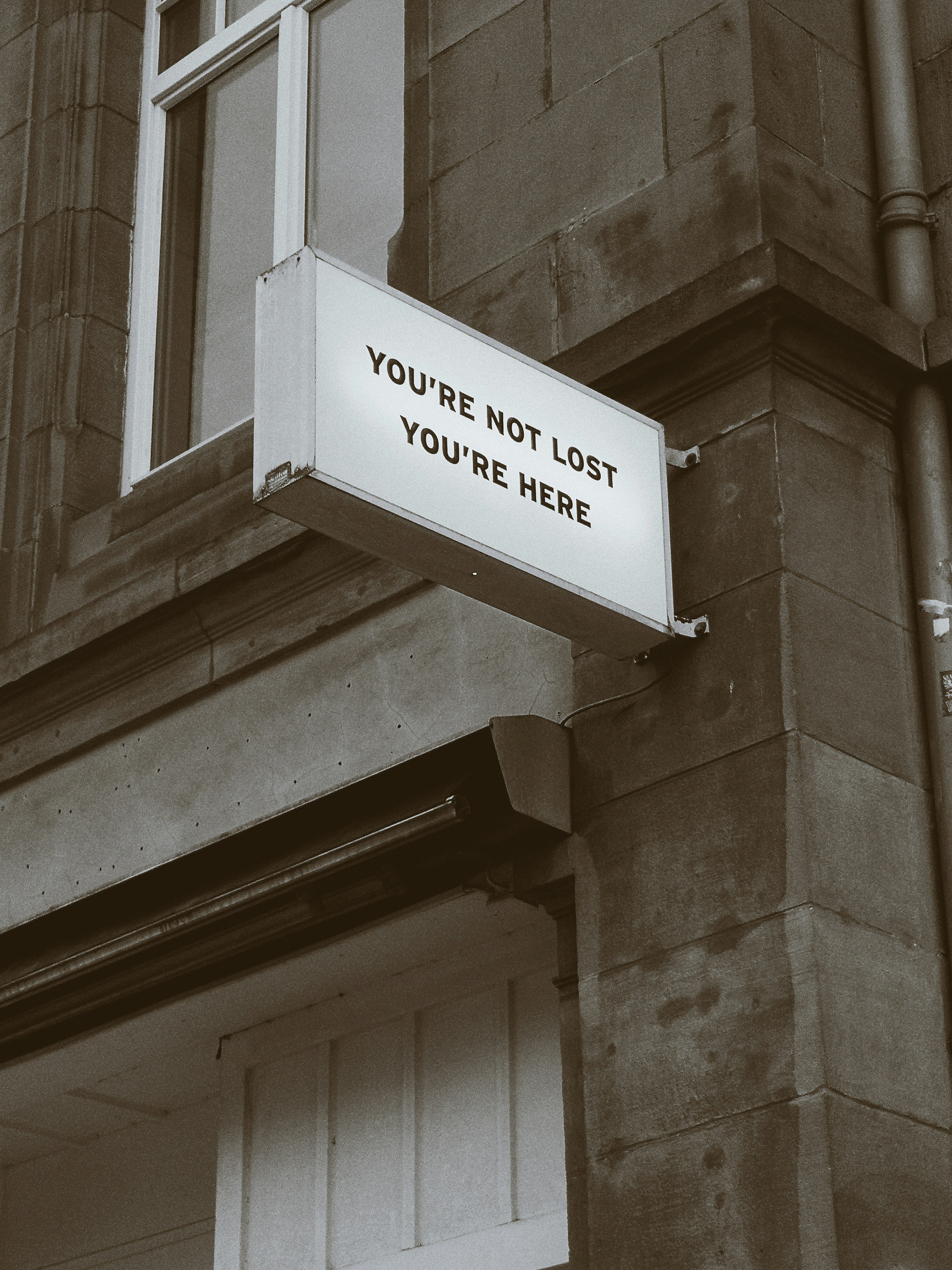 a small sign on a building reading you're not lost, you're here