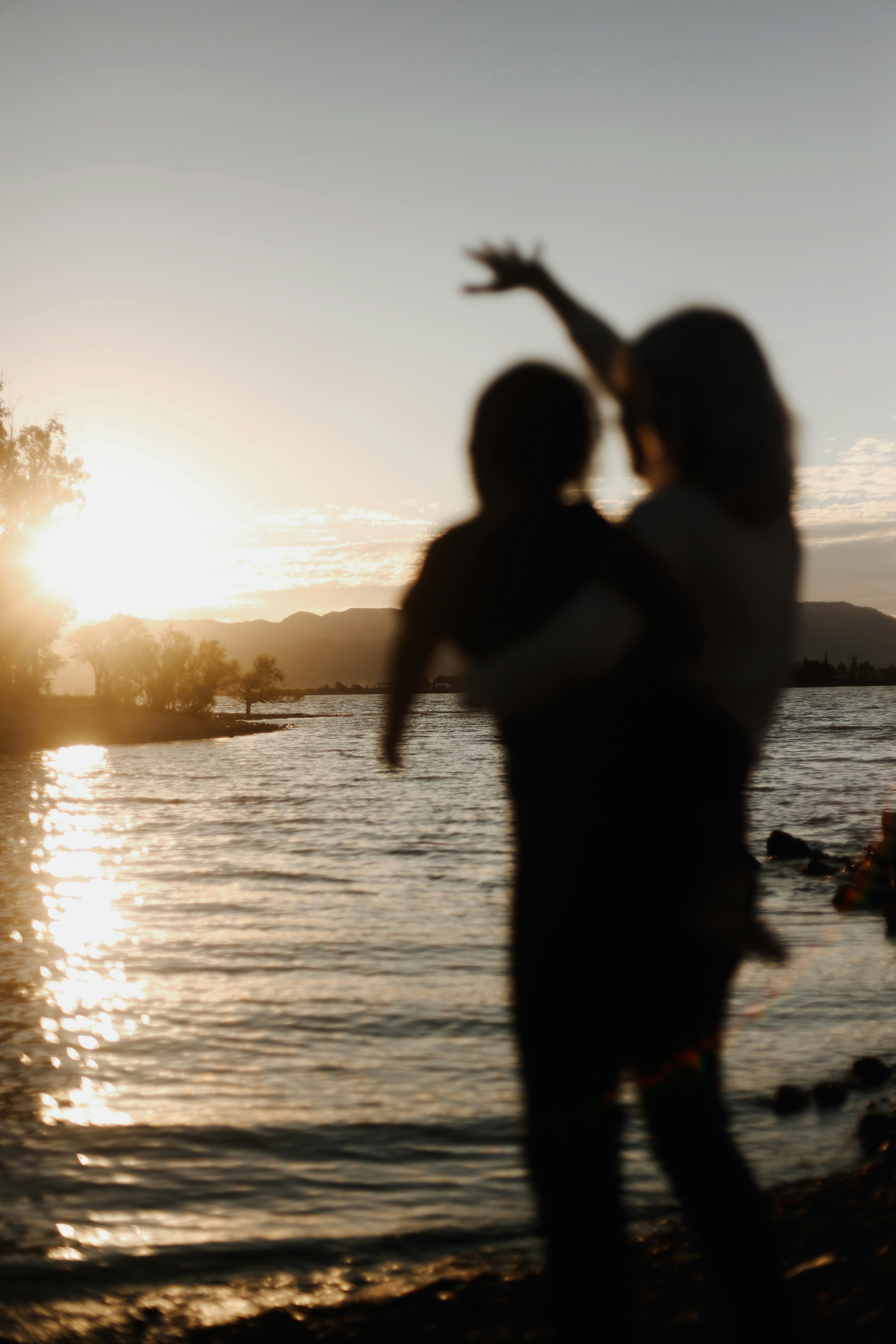a parent lifting a child at the water's edge