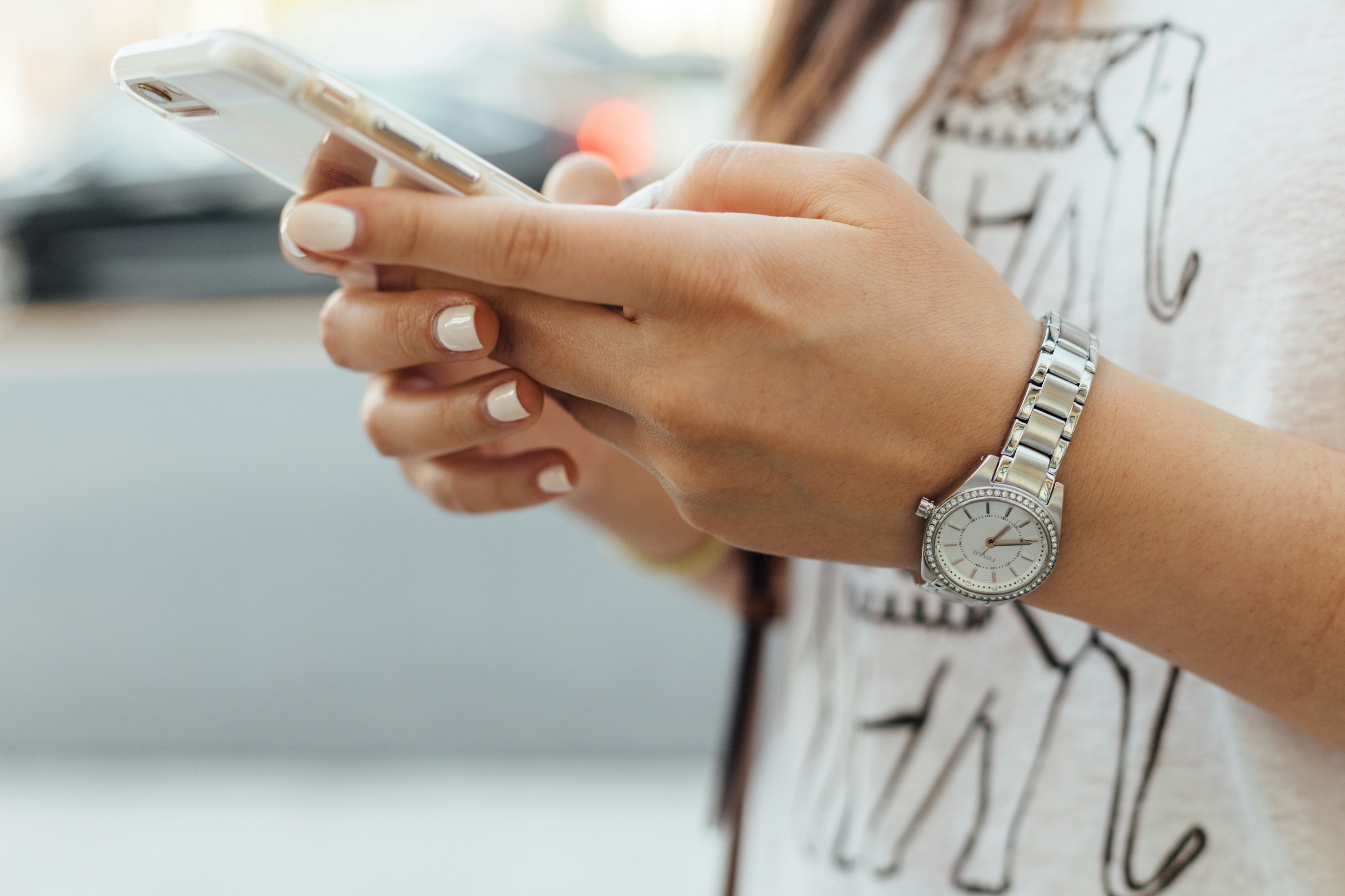 hands holding a phone, a watch on one wrist