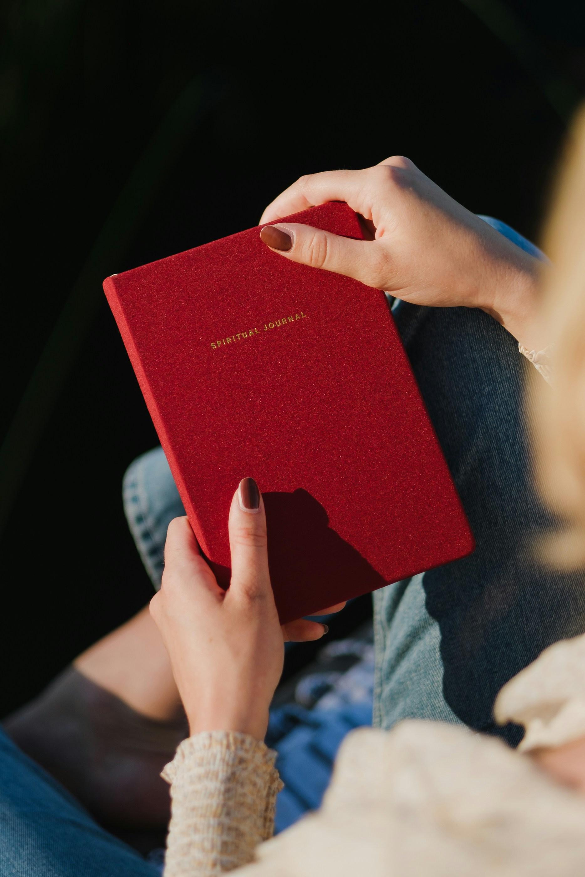 a child and adult sitting together with a red notebook