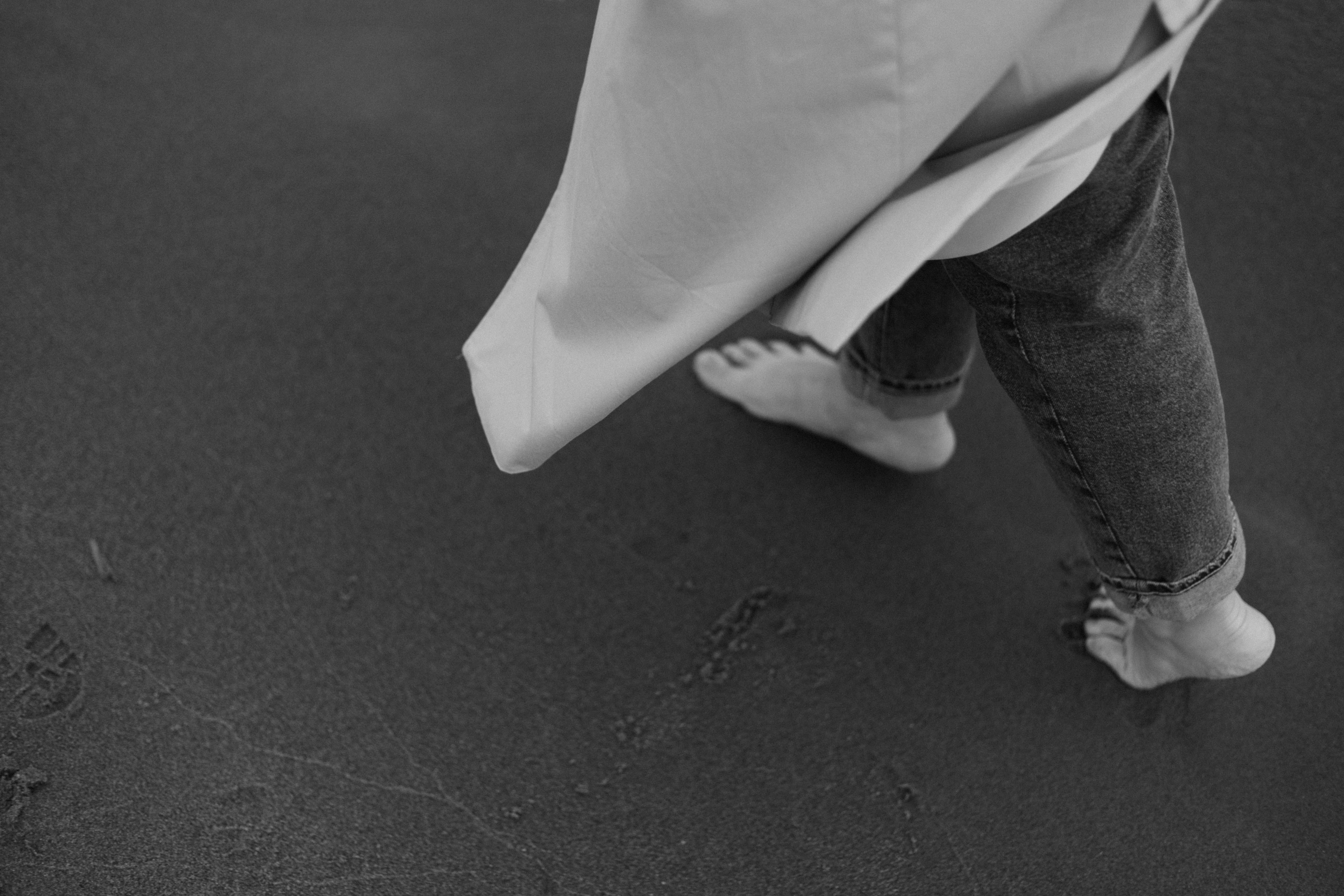 bare feet and rumpled linen on a dark floor