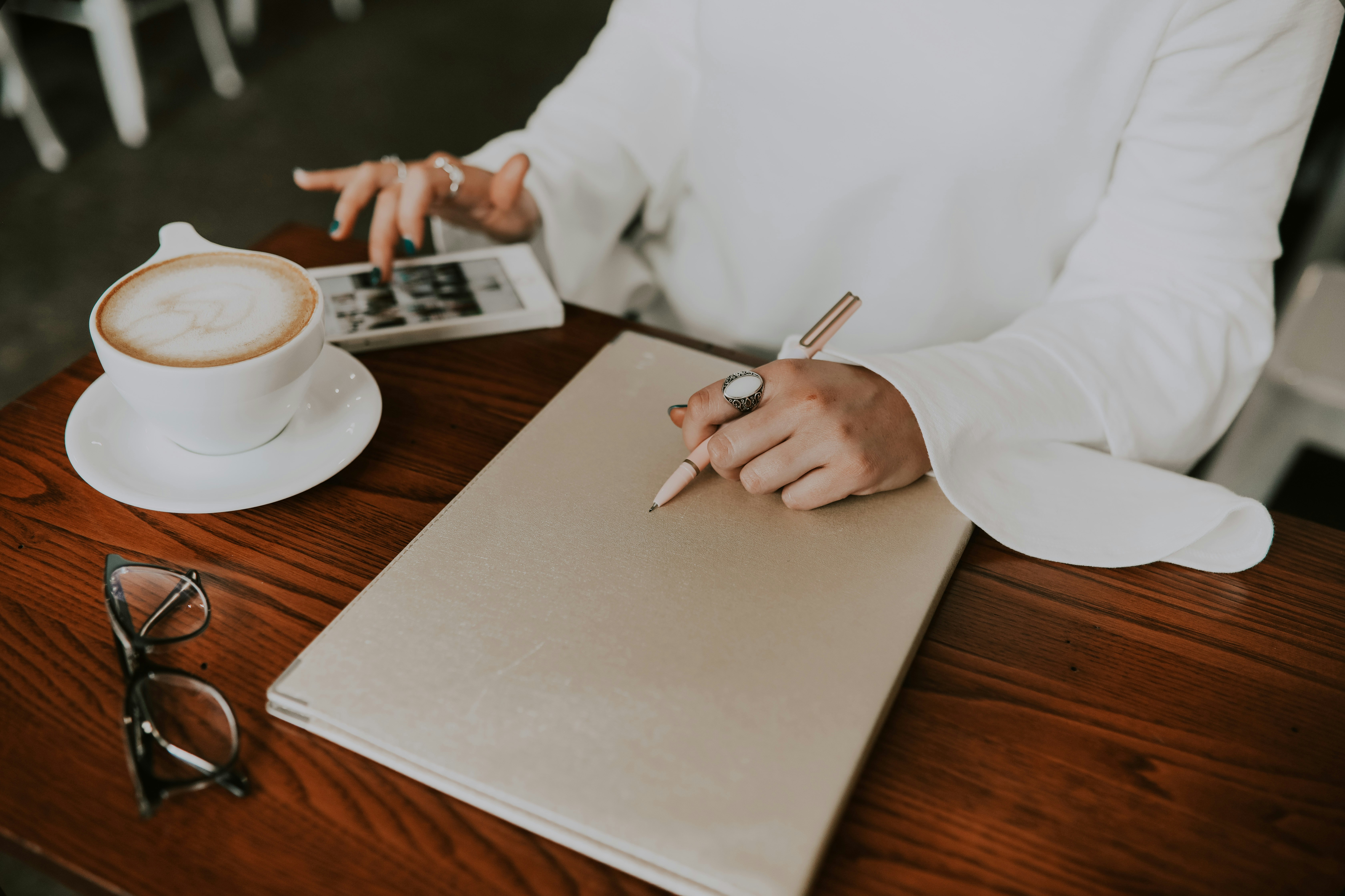 a cup of coffee and a notebook on a cafe table