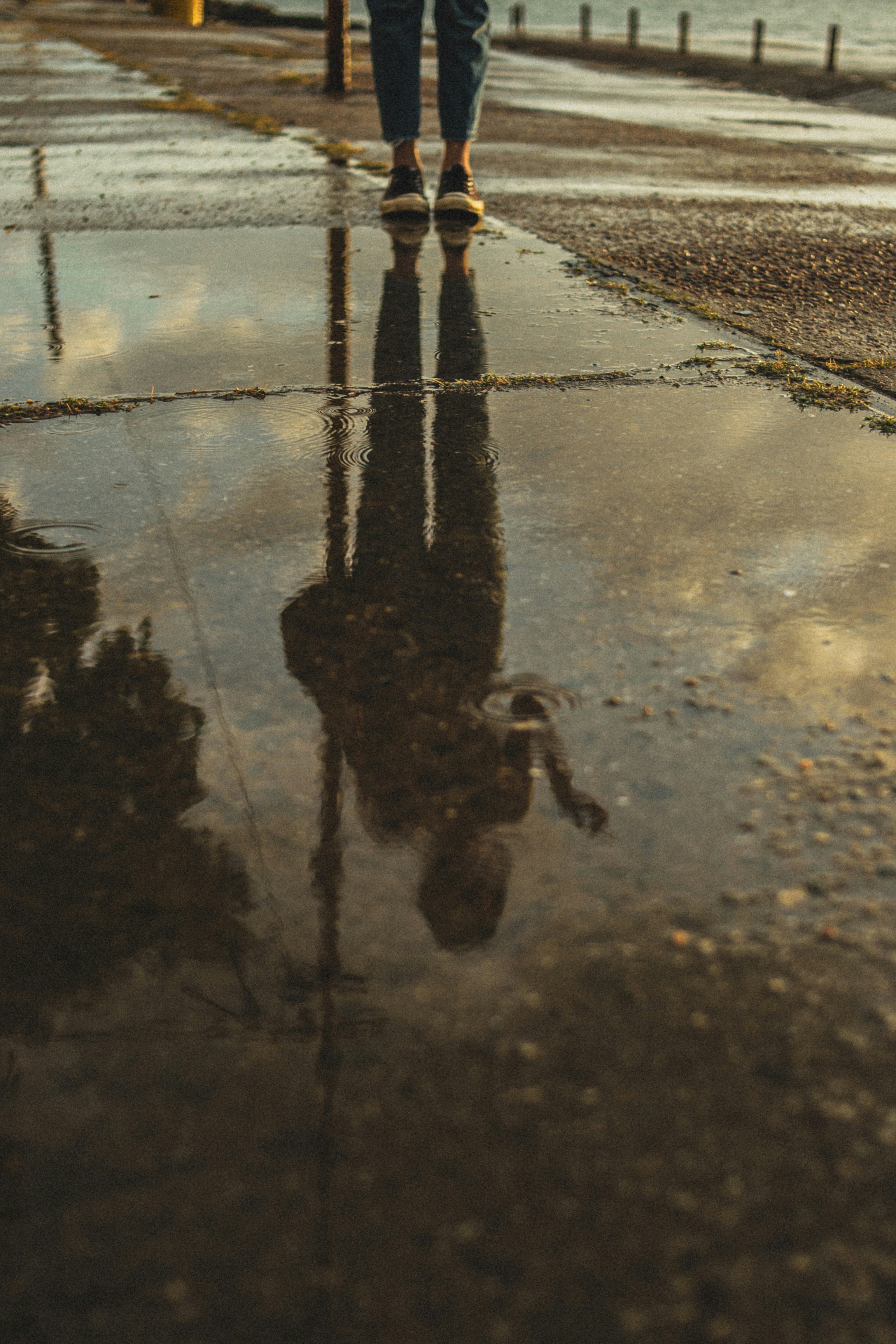 a figure reflected in wet pavement