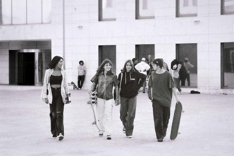 teenagers walking together carrying skateboards