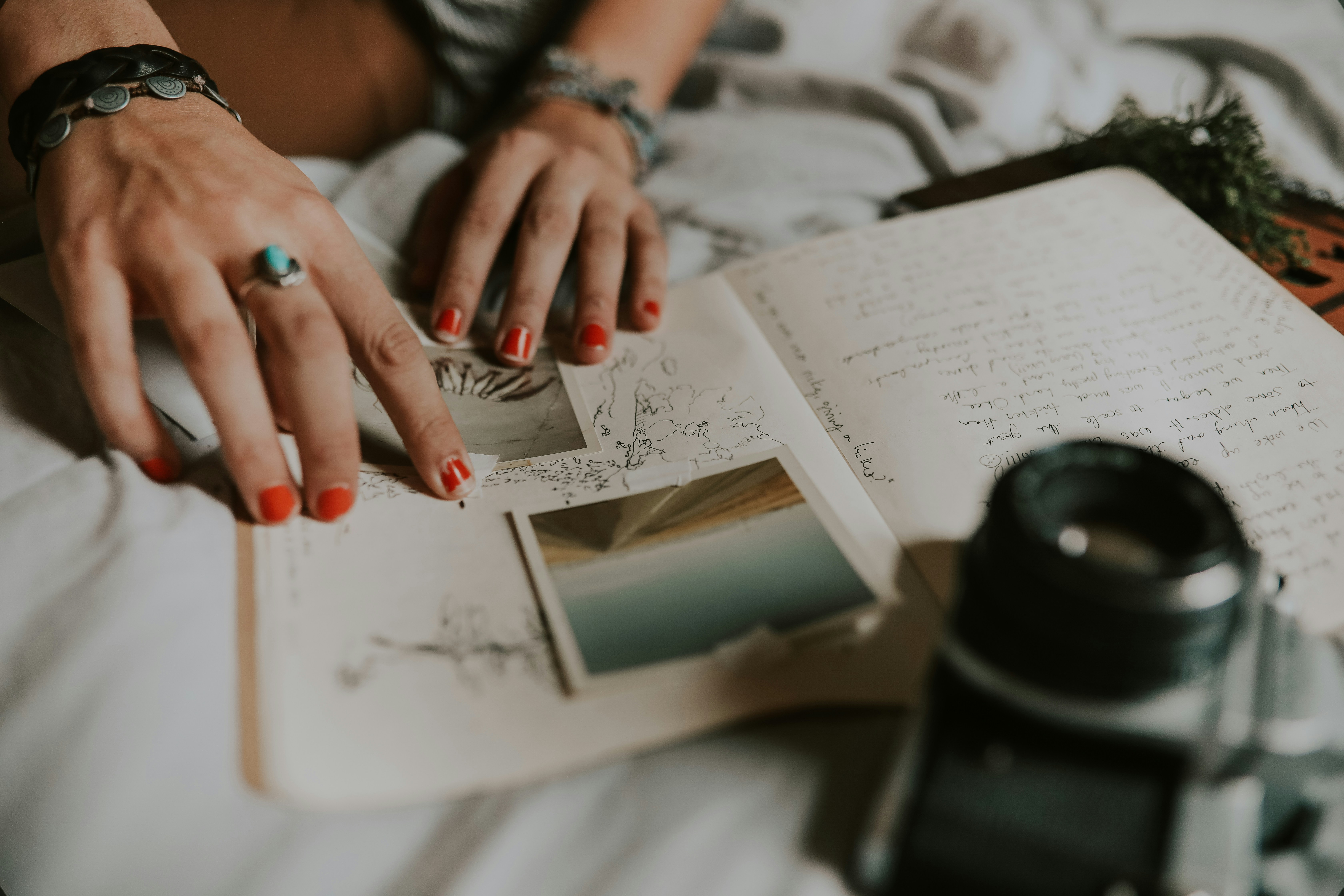 hands writing in a notebook beside a cup of coffee