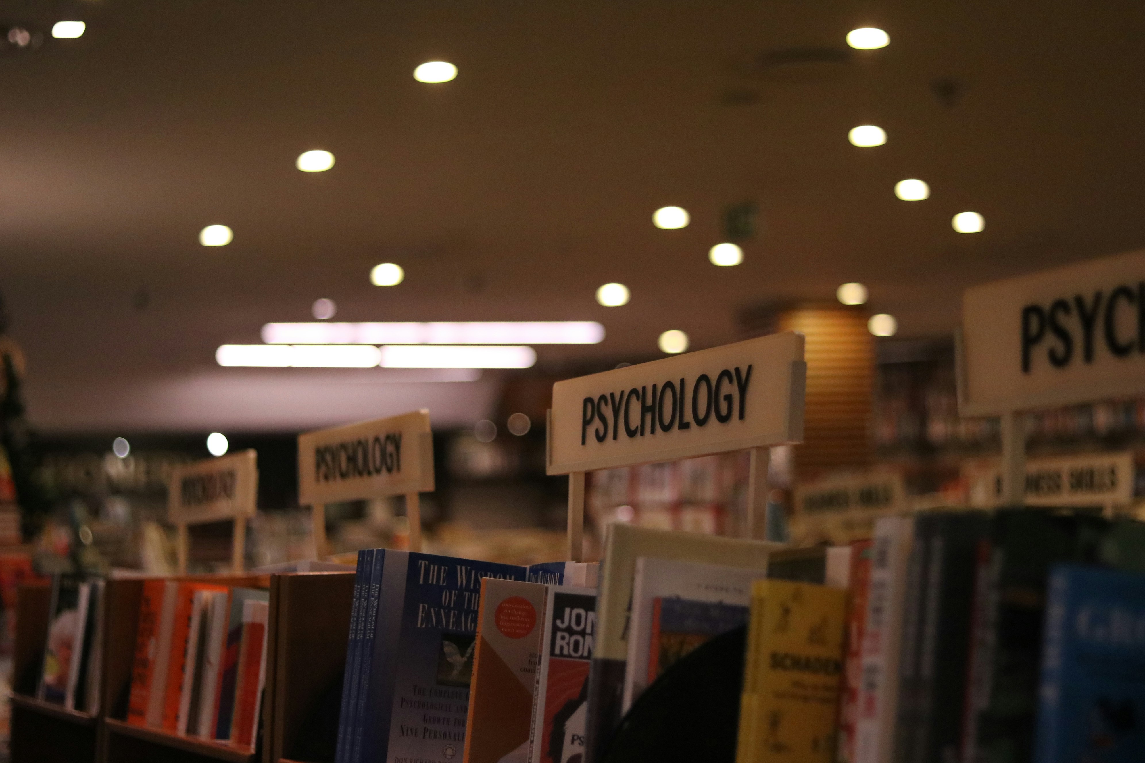 the psychology shelves of a bookshop under strip lighting