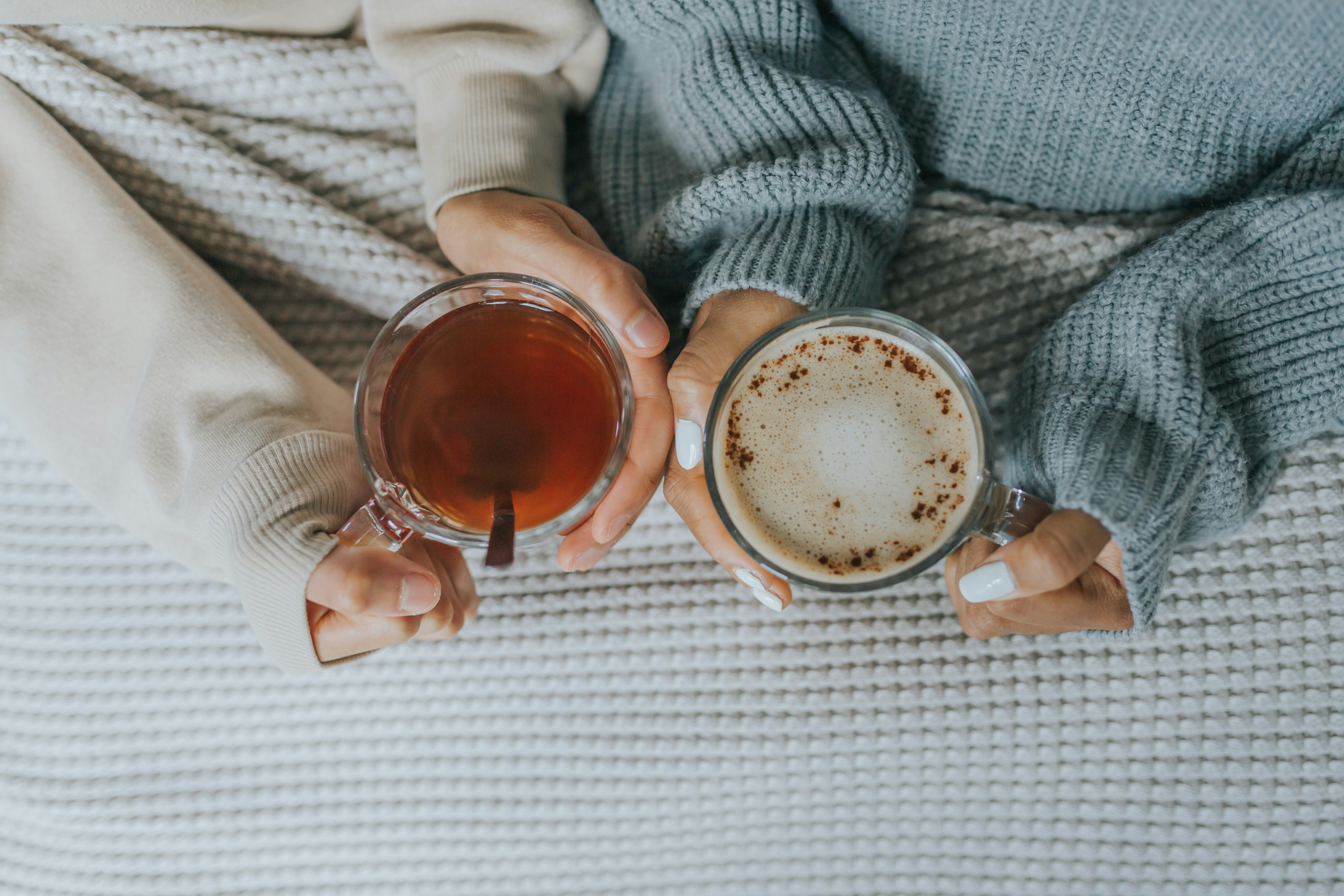 two mugs held over a knitted blanket