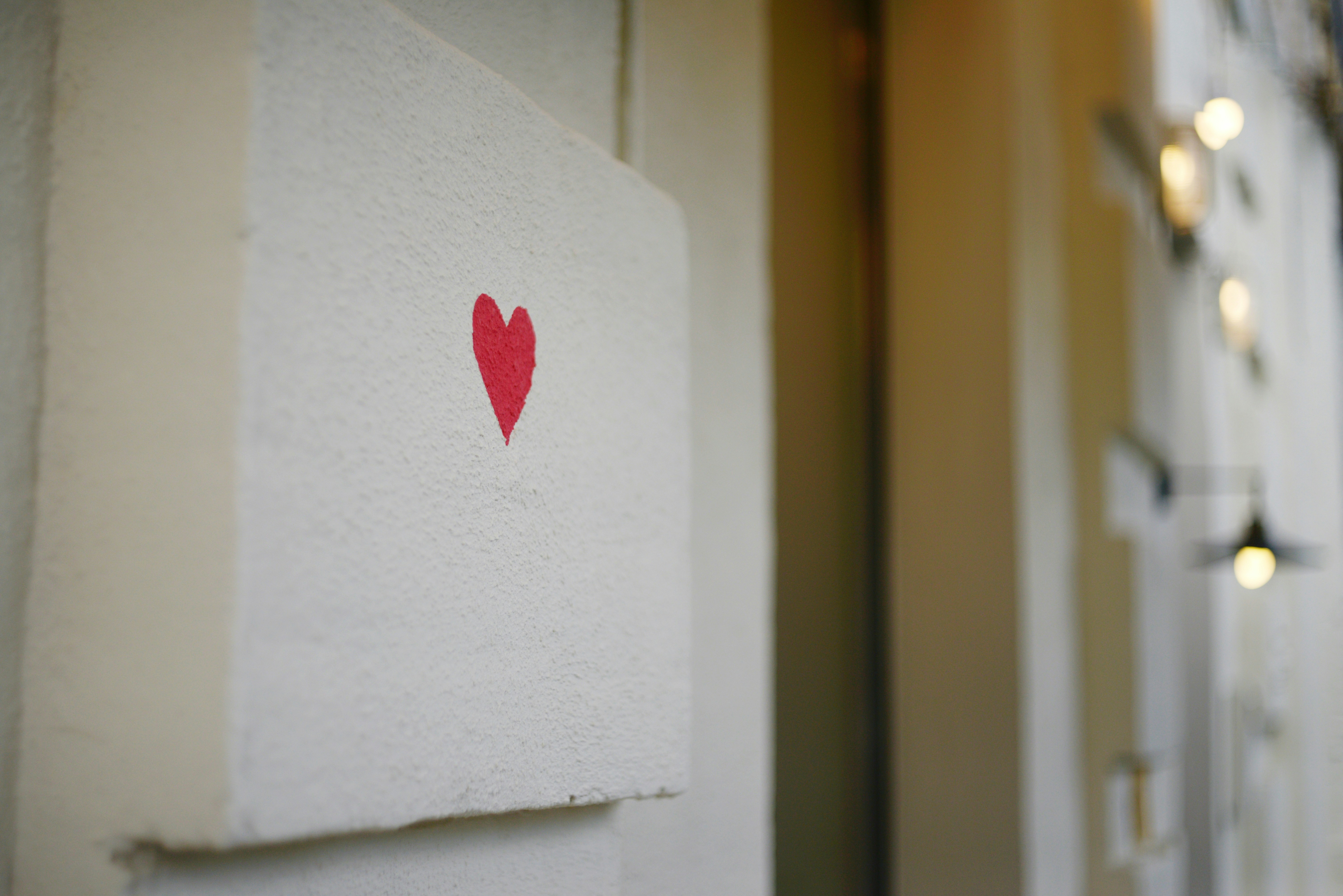 a small red heart painted on a white wall