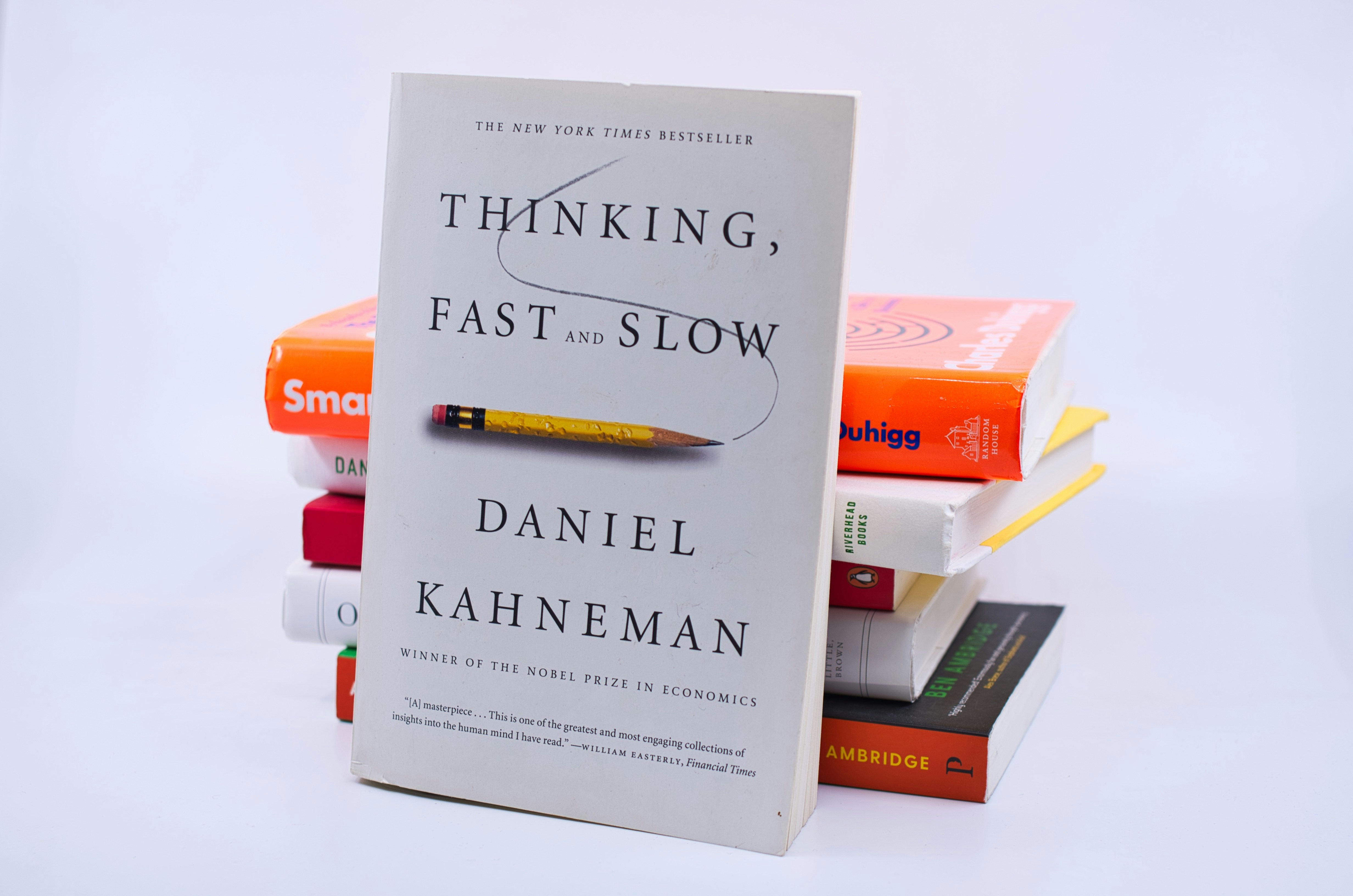 a stack of nonfiction books topped with Thinking, Fast and Slow