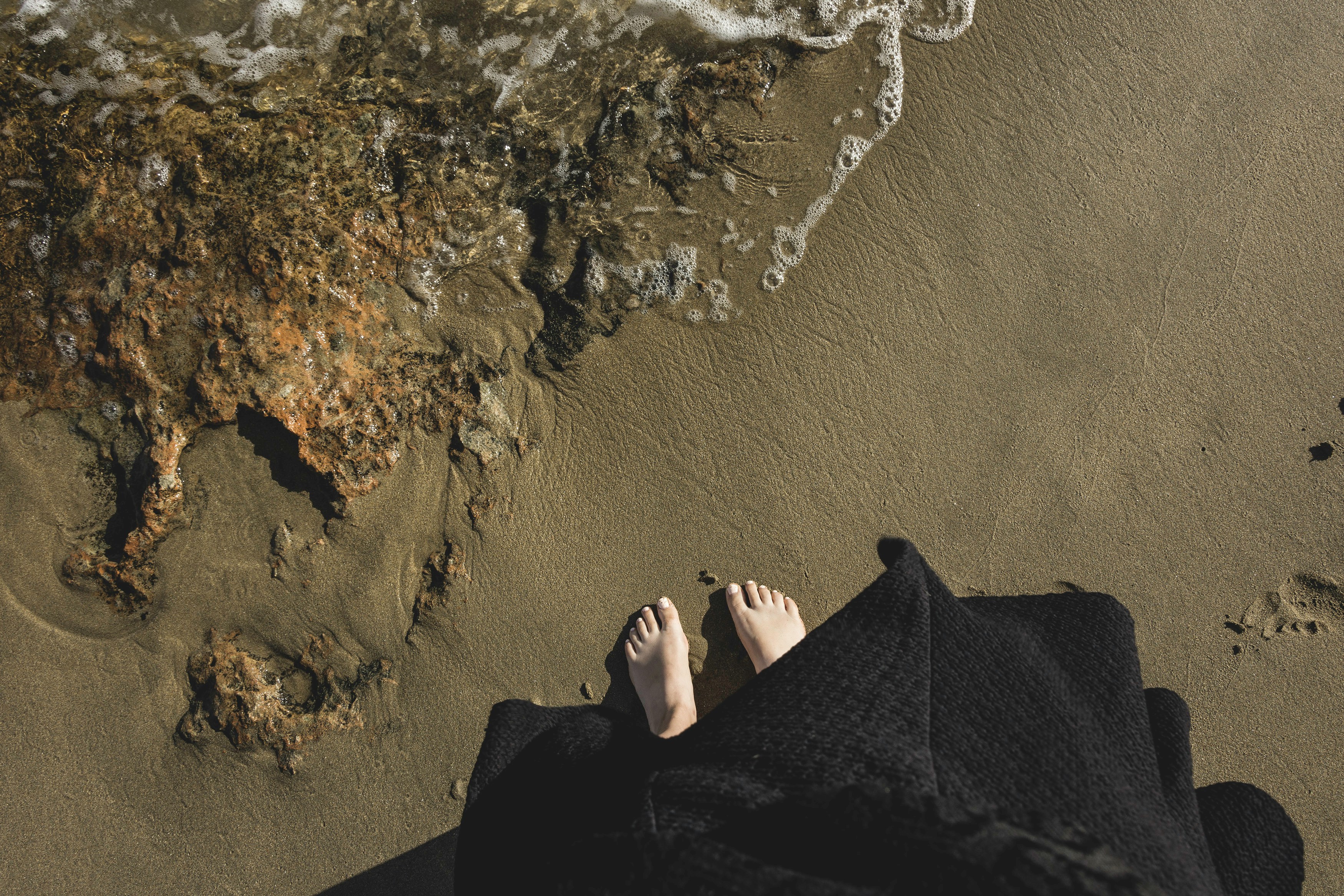 bare feet at the edge of the shoreline