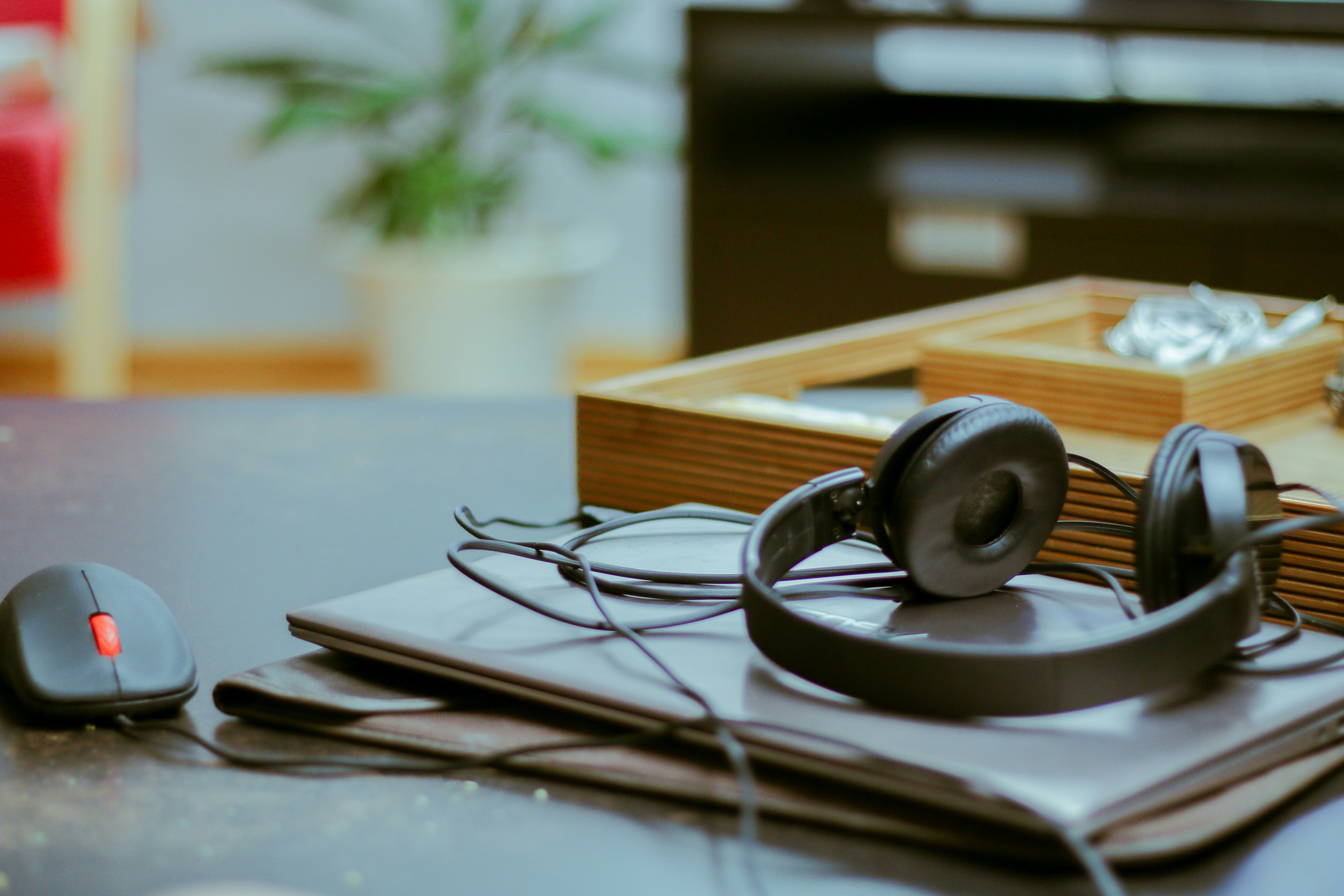 Headphones, a notebook and a laptop left mid-use on a desk