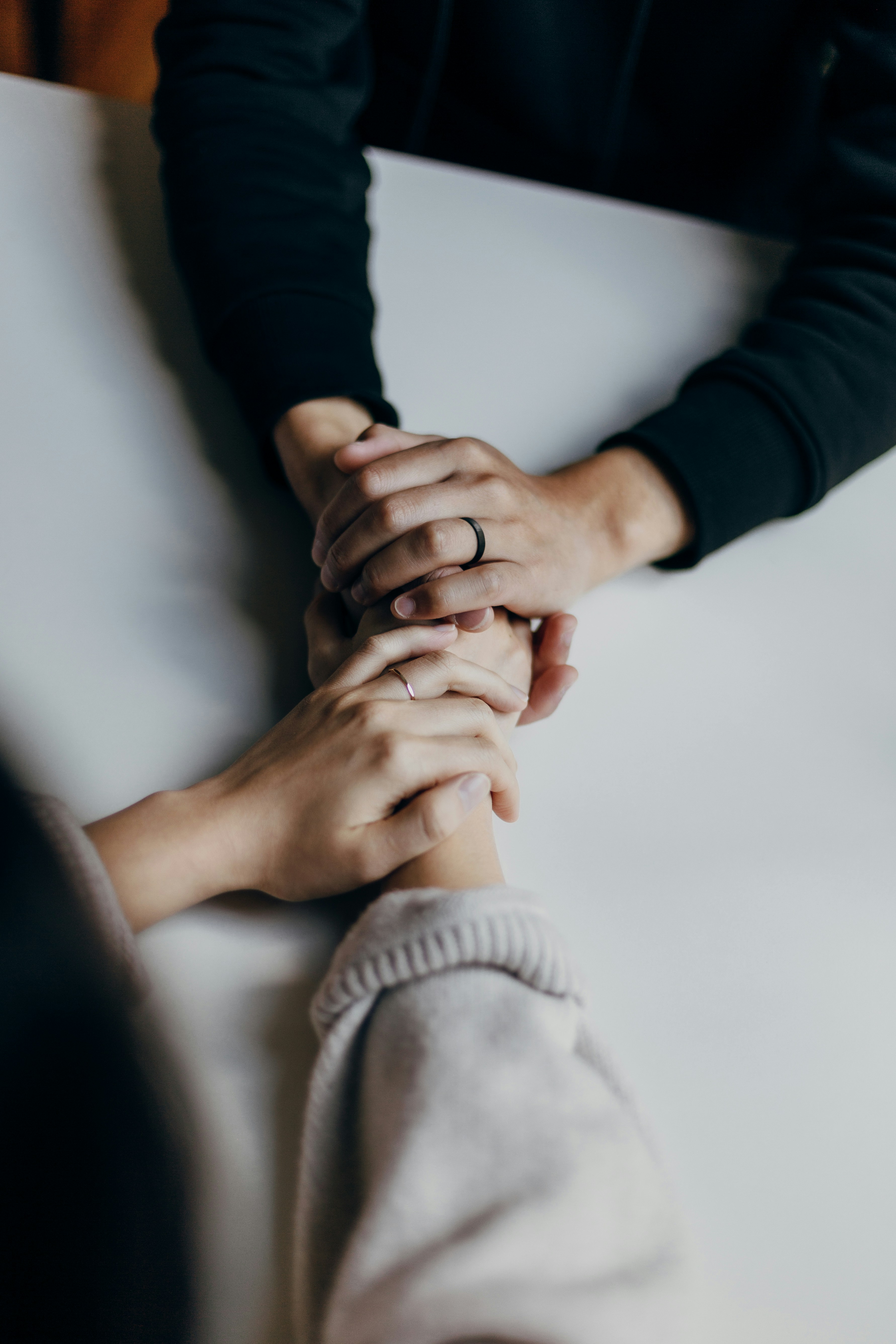 two pairs of hands held together across a table