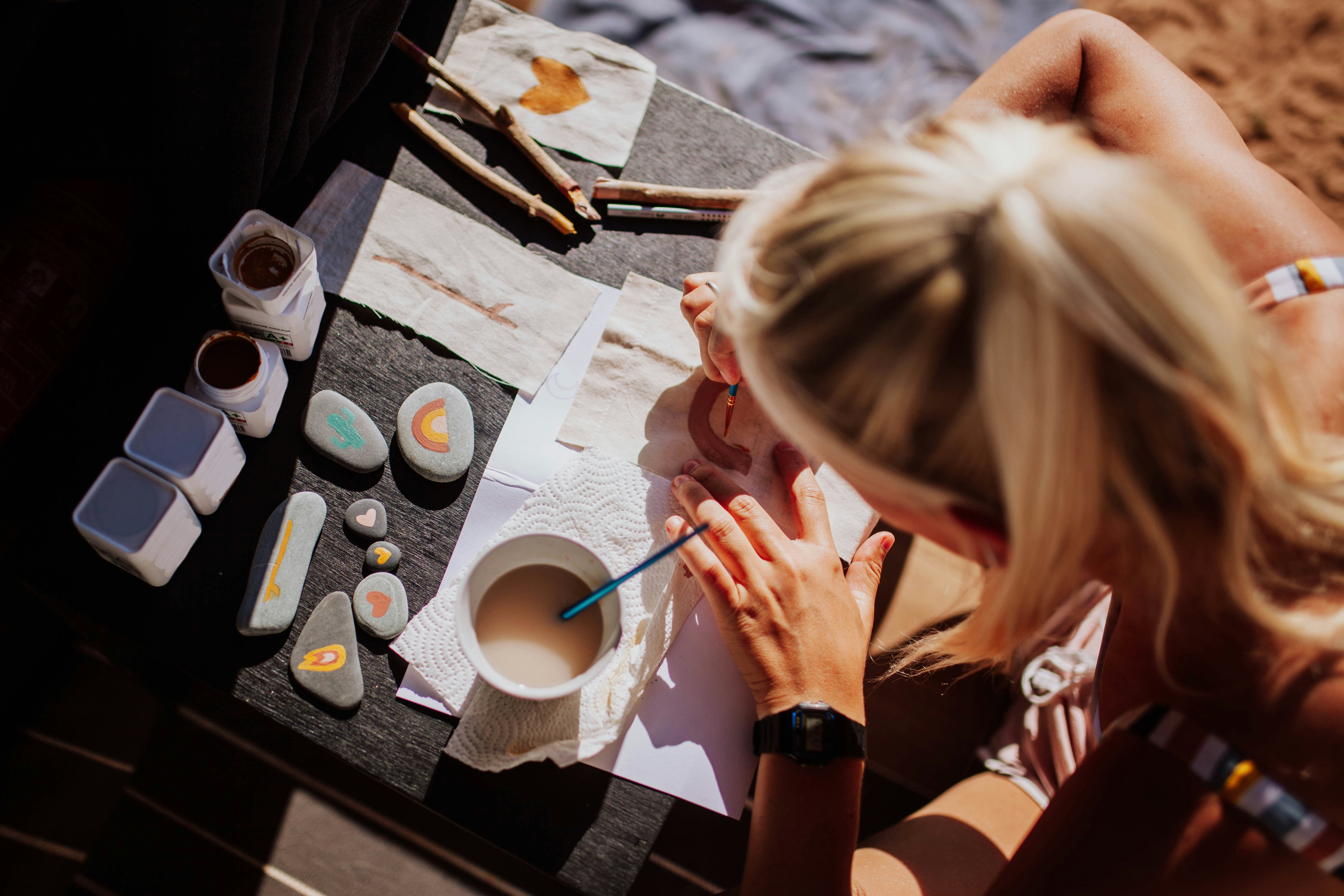 two people painting ceramics together at a craft table