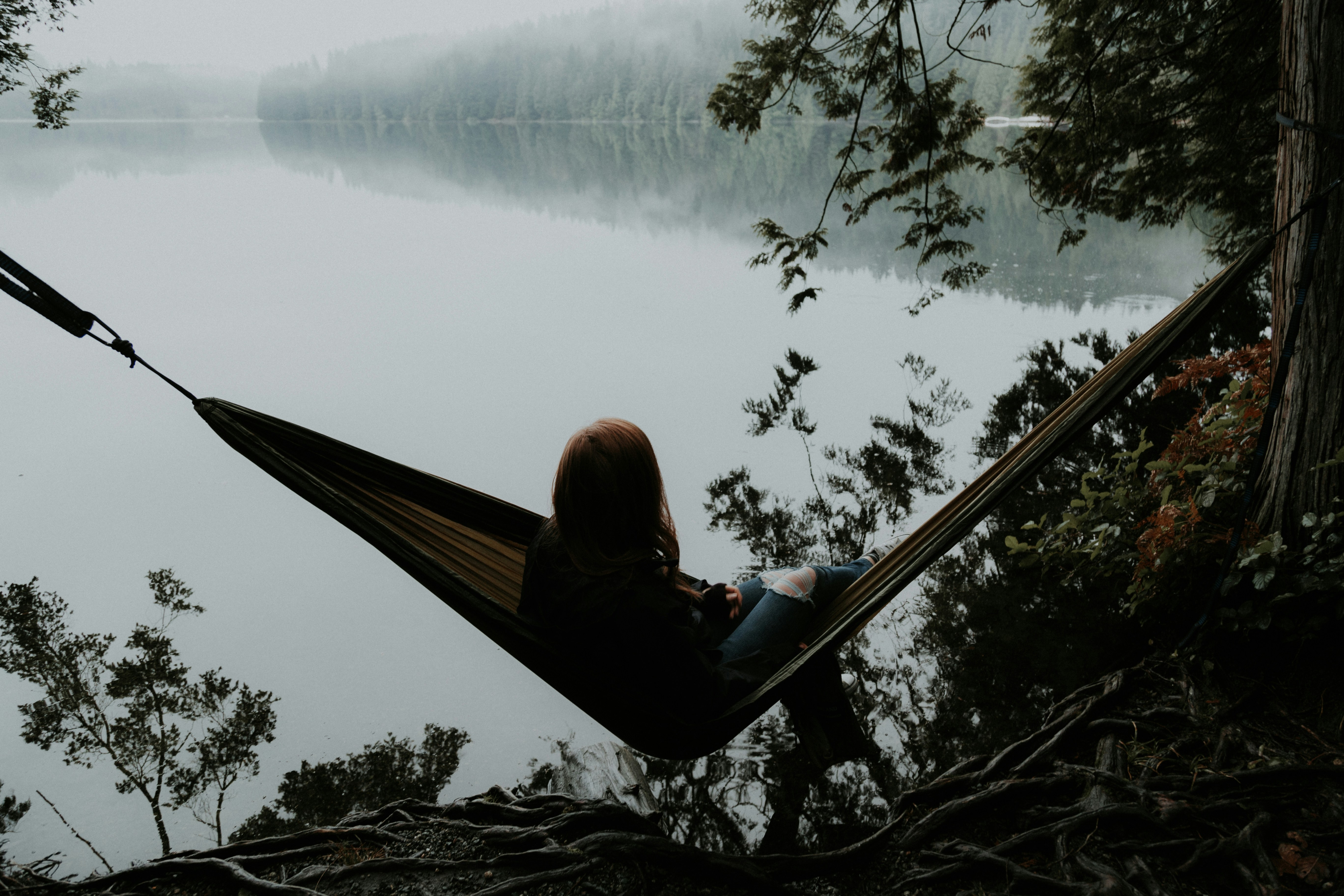 someone lying in a hammock under the trees